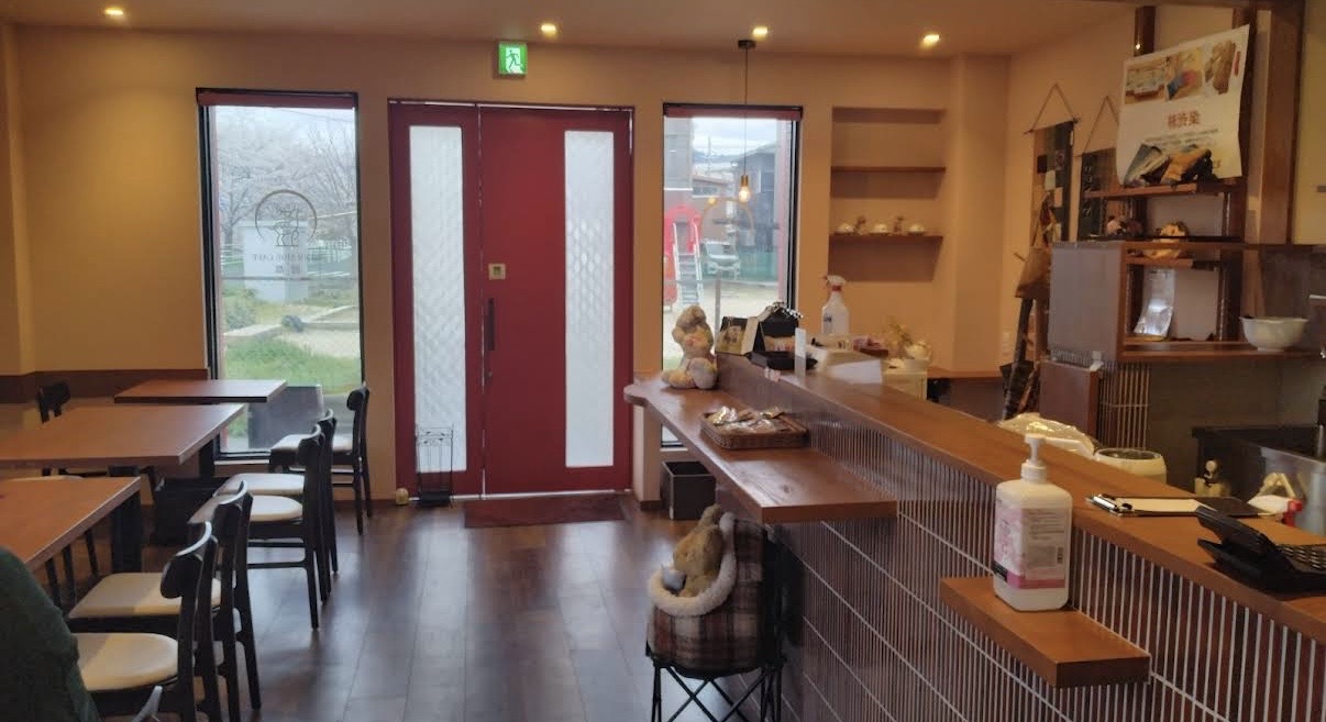 赤い扉と窓から光が差し込む店内